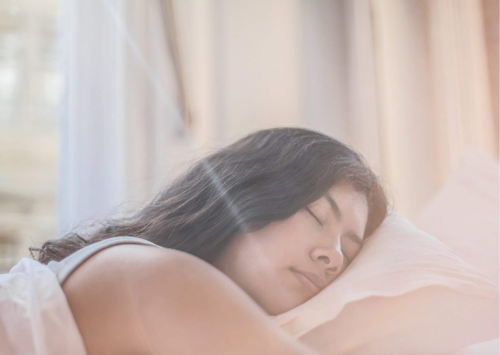 Woman peacefully sleeping on a pillow, emphasizing the importance of sleep in relation to TMS treatment efficacy.