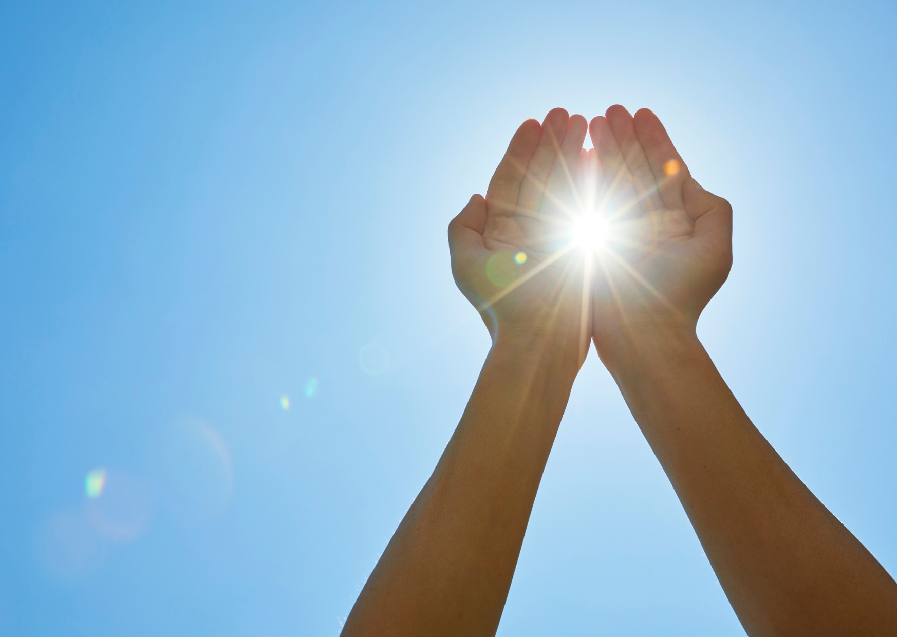 Hands raised towards the sun, symbolizing hope and wellness, in the context of improving TMS results through natural habits like morning sunlight.